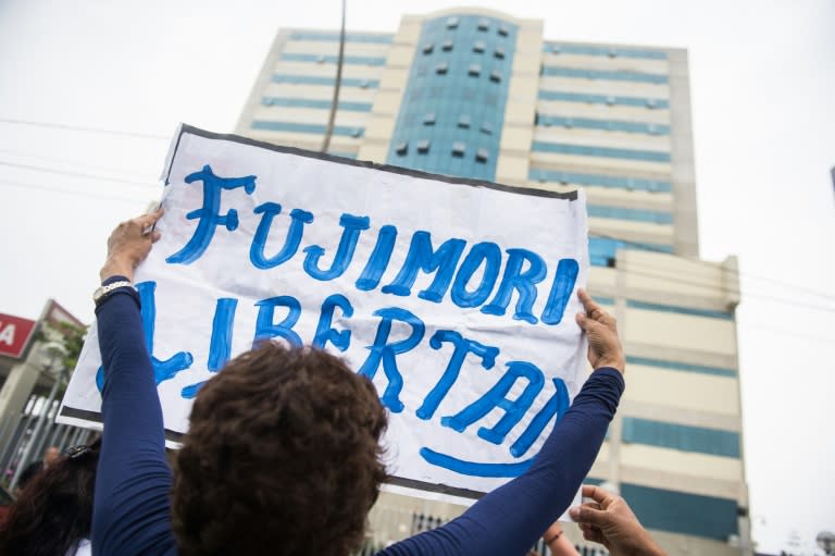 A supporter of Peru's ex-president Alberto Fujimori gathers with others outside the Lima hospital where he was admitted, before being pardoned