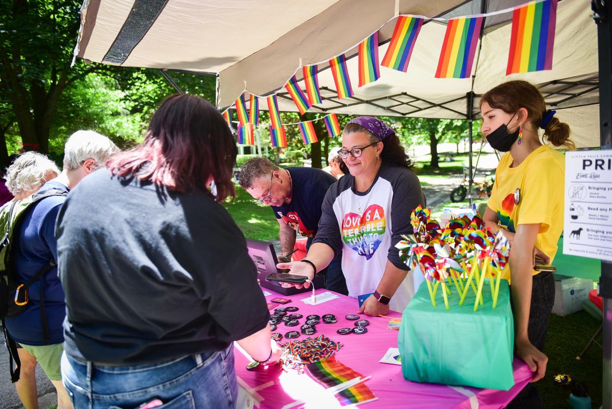 Guests buy merchandise during Pride Fest on Saturday, June 12, 2021, at Burke Park in Little Falls. The event was hosted by the Little Falls Community Outreach Center and started with a Pride Stride 5K and Family Fun Run in the morning. Events such as educational discussions, Q&A with the audience, drag story hour and others followed. Merchandise was for sale, including food vendors, music, lawn games and arts and crafts. The day ended with a pride dance party.