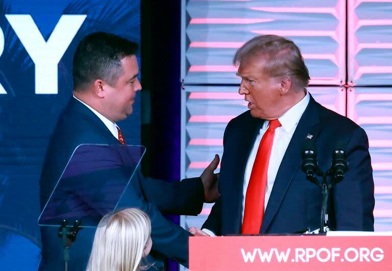 El presidente del Partido Republicano de Florida Christian Ziegler, izquierda, saluda al expresidente Donald Trump en la Cumbre RPOF Freedom, el 4 de noviembre de 2023 en Kissimmee, Florida