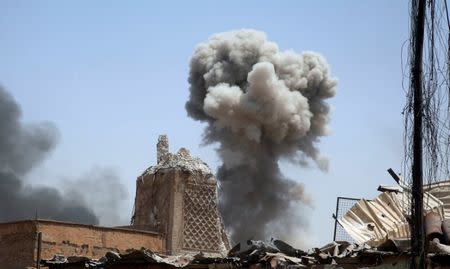 Smoke billows next to the remains of al-Hadba minaret at ruined Grand al-Nuri Mosque after an artillery attack by the Islamic State militants at the positions of the Iraqi forces in the Old City in Mosul, Iraq July 2, 2017. REUTERS/Erik De Castro