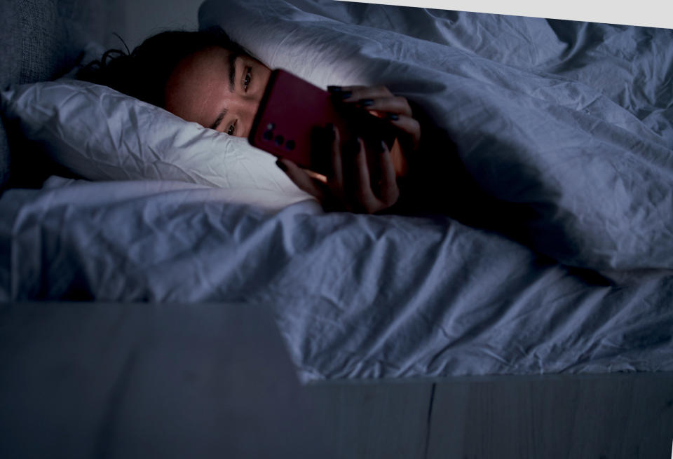 a woman looking at her phone in the dark