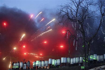 Ukranian riot police take cover behind their shields during clashes with anti-government protesters near Independence Square in Kiev February 18, 2014. REUTERS/Konstantin Chernichkin