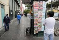 Foto del martes de un hombre leyendo las portadas de los diarios en Lima