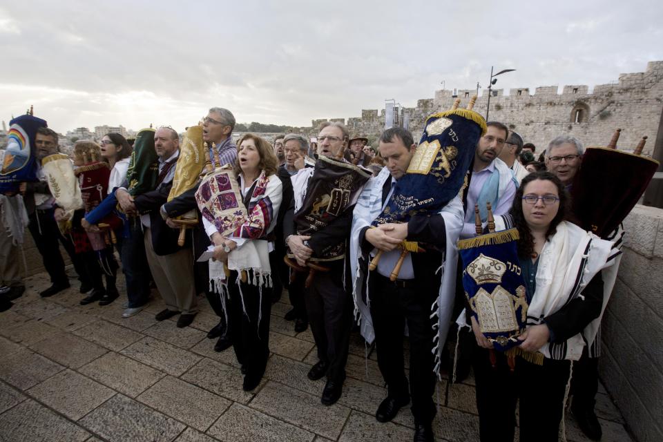 The heads of the Jewish Reform and Conservative movements carry Torah scrolls as they march to the Western Wall in Jerusalem's Old City in 2016. Israel's Supreme Court on Monday bucked Israel's powerful Orthodox establishment when it ruled that people who convert to Judaism through the Reform and Conservative movements in Israel also are Jewish and entitled to become citizens. (Photo: Sebastian Scheiner/Associated Press)