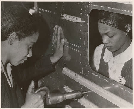 Evelyn T. Gray, Riveter, and Pearlyne Smiley, Bucker, complete a job on the center section of a bomber in this undated handout photo. U.S. National Archives/Handout via REUTERS