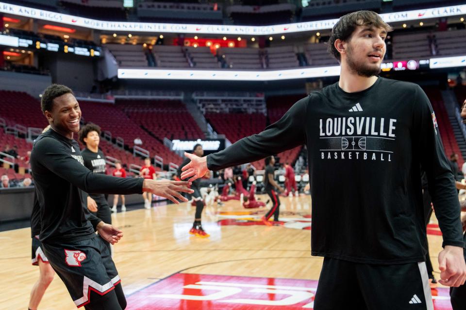 Louisville Cardinals Curtis Williams (1) and Danilo Jovanovich (13) stretch ahead of their game against the Florida State Seminoles on Saturday, Feb. 3, 2024 at KFC YUM Center.