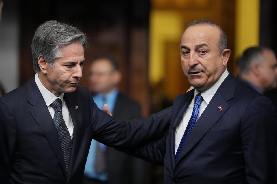 Turkey's Foreign Minister Mevlut Cavusoglu, right, talks with United States Secretary of State Antony Blinken as they arrive for a family photo during the first day of the meeting of NATO Ministers of Foreign Affairs, in Bucharest, Romania, Tuesday, Nov. 29, 2022. (AP Photo/Andreea Alexandru)