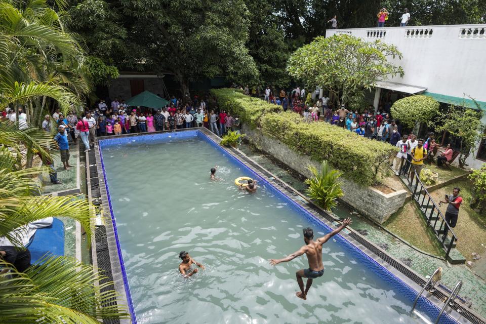 Protesters swim as onlookers wait at a swimming pool in the president's official residence a day after it was stormed in Colombo, Sri Lanka, July 10, 2022. The image was part of a series of images by Associated Press photographers that was a finalist for the 2023 Pulitzer Prize for Breaking News Photography. (AP Photo/Eranga Jayawardena)
