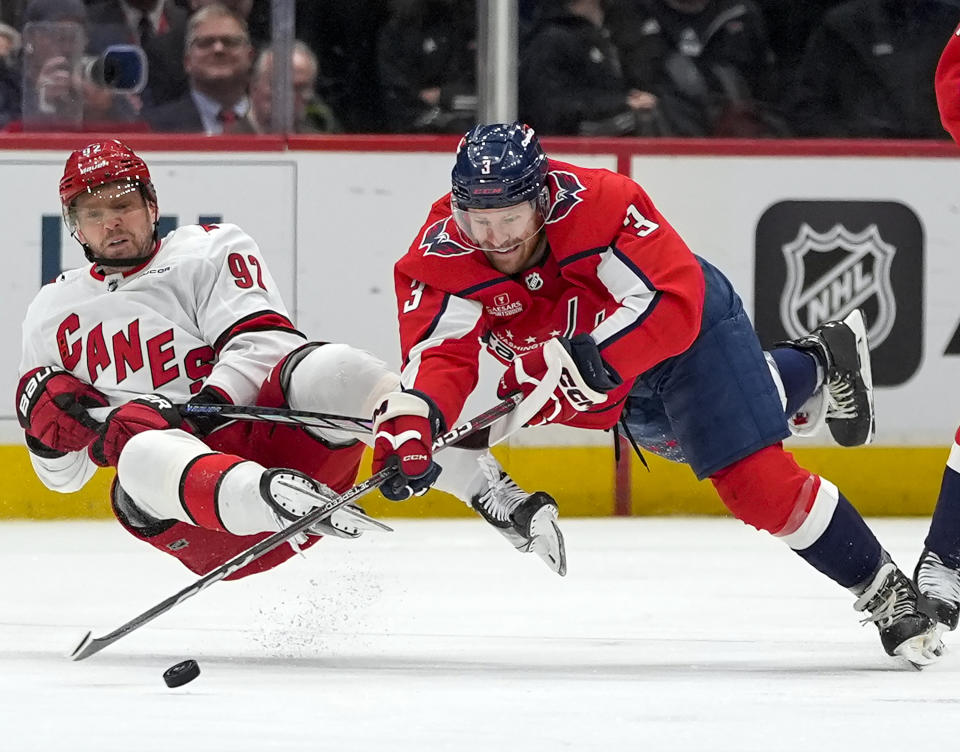Carolina Hurricanes center Evgeny Kuznetsov, left, and Washington Capitals defenseman Nick Jensen, right, collide as they go for the puck in the first period of an NHL hockey game Friday, March 22, 2024, in Washington. (AP Photo/Alex Brandon)