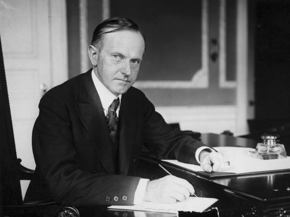 Coolidge writing at his desk.