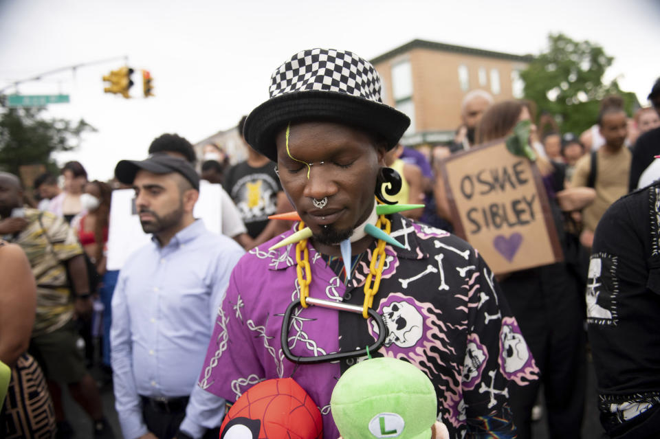 CORRECTS SECOND SENTENCE - JoJo Clubkid takes part in a moment of silence during a vigil to memorialize O'Shae Sibley at a gas station on Friday, Aug. 4, 2023, in the Brooklyn borough of New York. Sibley, a gay man, was fatally stabbed at the gas station after a confrontation between a group of friends dancing to a Beyoncé song and several young men who taunted them. (AP Photo/Tracie Van Auken)