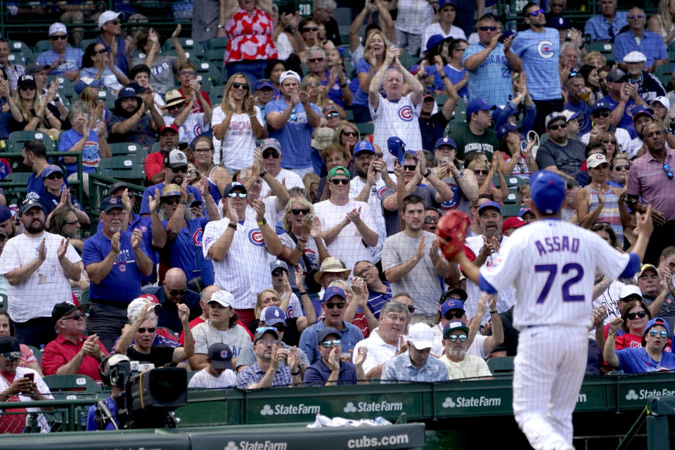 Chicago Cubs starting pitcher Javier Assad receives a standing ovation from the Wrigley Field crowd as he is pulled in the fifth inning of a baseball game and his Major League debut, against the St. Louis Cardinals Tuesday, Aug. 23, 2022, in Chicago. (AP Photo/Charles Rex Arbogast)