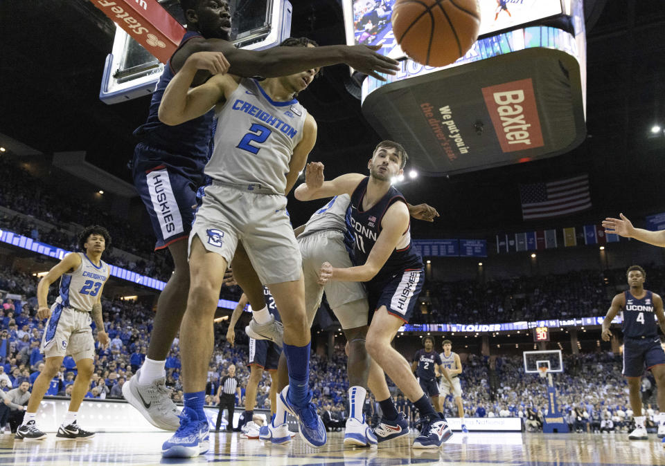 UConn's Adama Sanogo, left, and Alex Karaban, right, reach for a rebound against Creighton's Ryan Nembhard, second left, and Fredrick King during the first half of an NCAA college basketball game on Saturday, Feb. 11, 2023, in Omaha, Neb. (AP Photo/Rebecca S. Gratz)