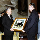 FILE - Japanese Foreign Minister Masayoshi Ohira, left, receives a photo of a panda named Huan Huan from Chinese Prime Minister Hua Guofeng in Beijing in December 1979. Tokyo's Ueno Zoo received Huan Huan from China in 1980, after Lan Lan, another Chinese gift, died in 1979. Thursday, Sept. 29, 2022, marks the 50th anniversary of the historic communique that former Japanese Prime Minister Kakuei Tanaka signed with former Chinese Premier Zhou Enlai. (Kyodo News via AP, File)