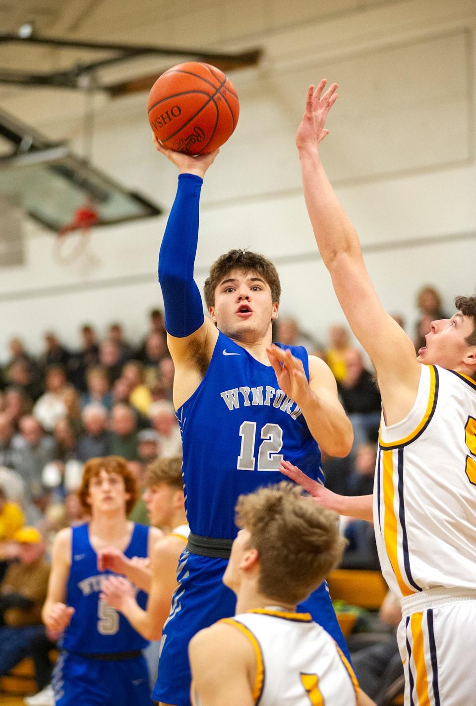 Wynford's Grant McGuire puts a shot up around Colonel Crawford's Braxton Baker.