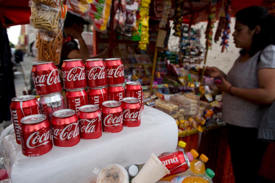 Cans of Coca-Cola sit on an ice block to keep cool at a street vendor's stand in Mexico City in 2014.