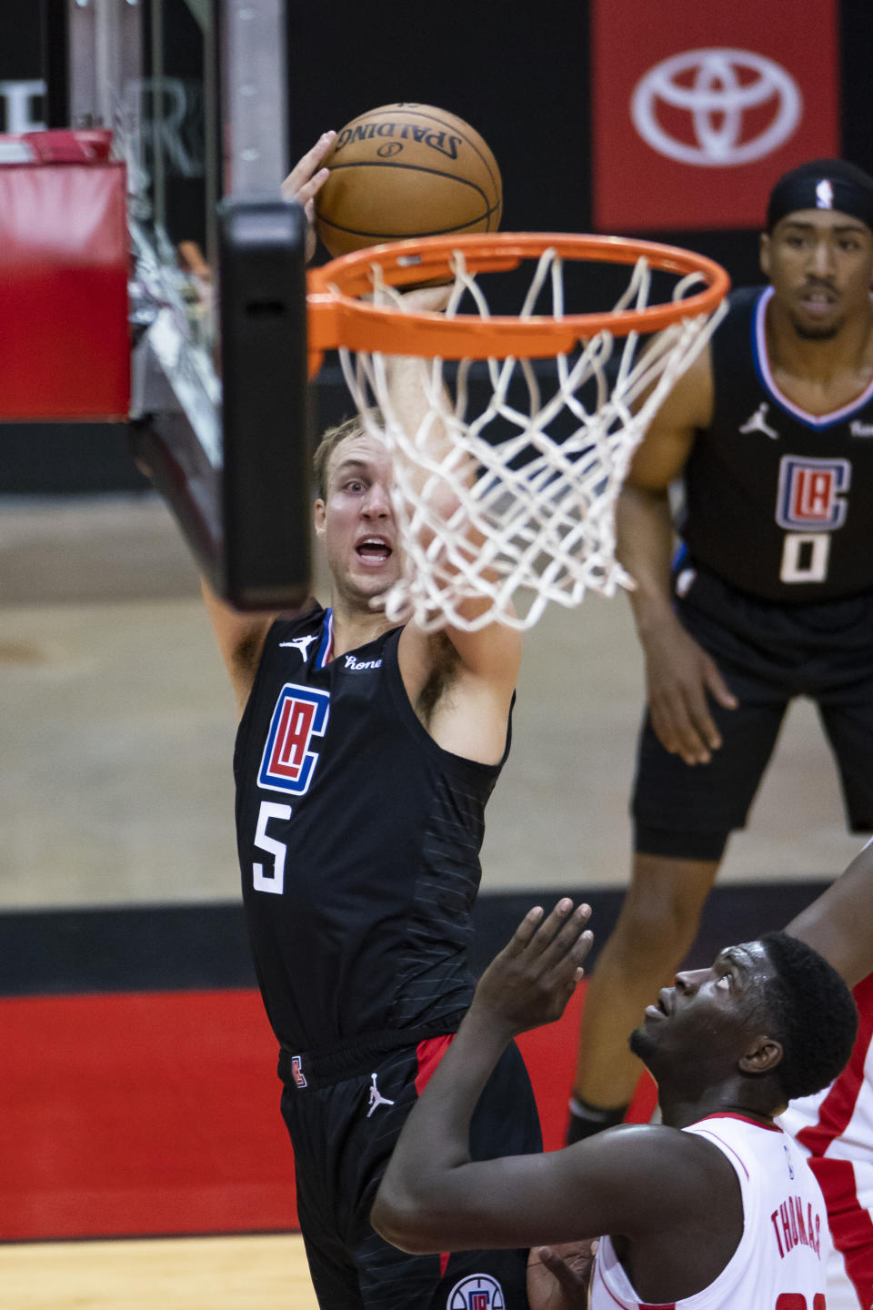 Los Angeles Clippers guard Luke Kennard (5) shoots over Houston Rockets forward Khyri Thomas (13) during the first quarter of an NBA game Friday, May 14, 2021, in Houston. (Mark Mulligan/Houston Chronicle via AP)