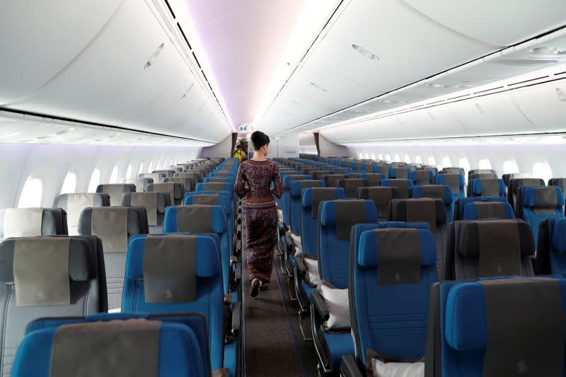 FILE PHOTO: A stewardess with Singapore Airlines walks through the economy seating of the airline's Boeing 787-10 Dreamliner after a delivery ceremony at the Boeing South Carolina plant in North Charleston