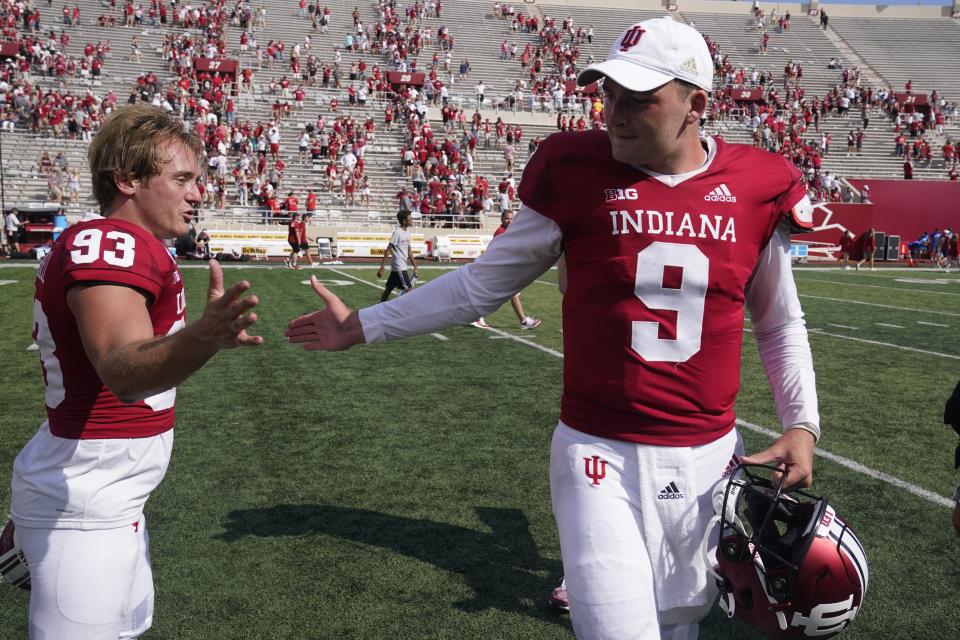 Indiana place kicker Charles Campbell (93) is congratulated by Indiana quarterback Connor Bazelak (9) after Campbell kicked a game winning field goal in overtime of an NCAA college football game against Western Kentucky, Saturday, Sept. 17, 2022, in Bloomington, Ind. Indiana won 33-30 in overtime. (AP Photo/Darron Cummings)