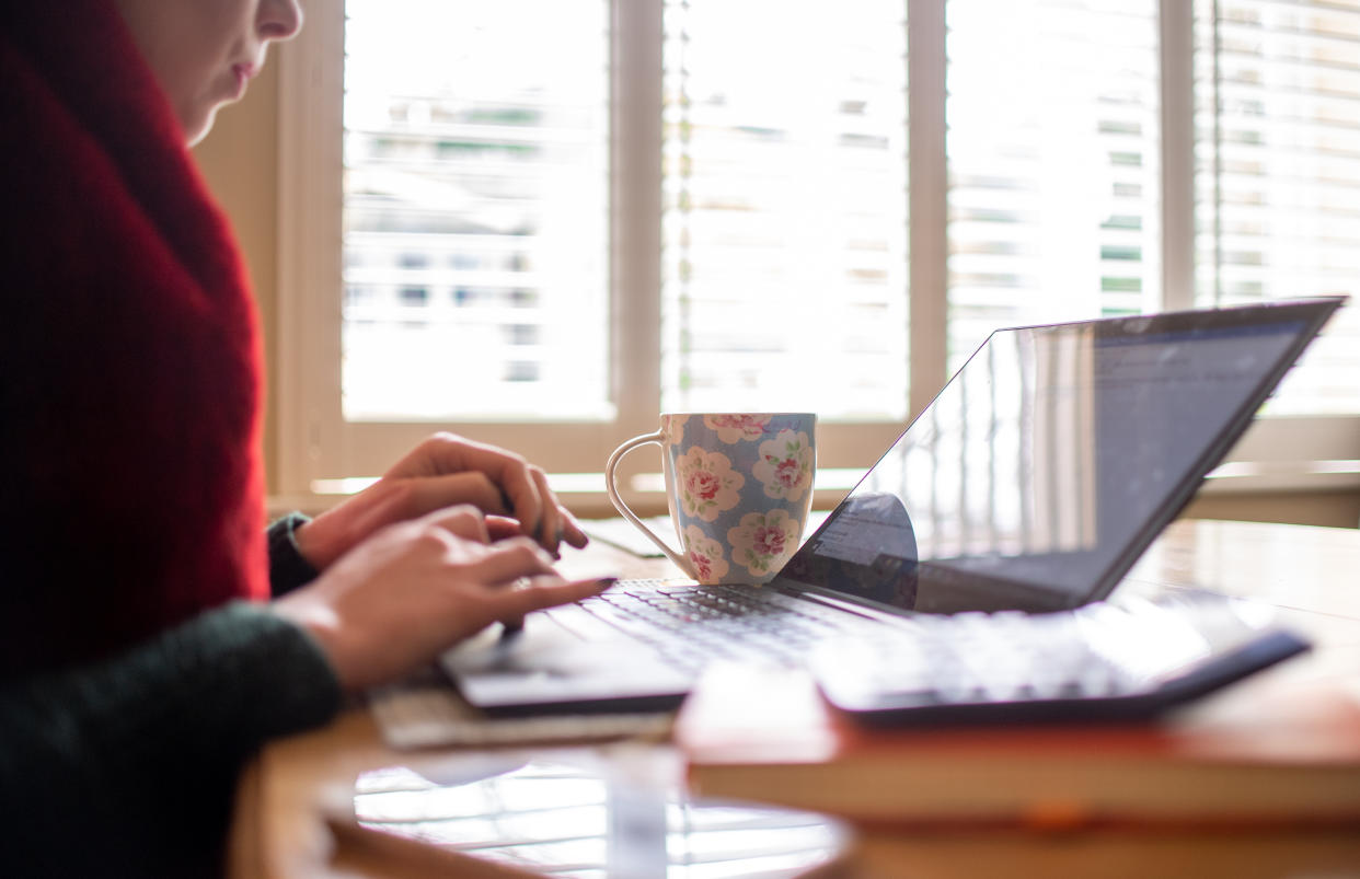 File photo dated 04/03/20 of a woman using a laptop on a dining room table set up as a remote office to work from home. Two out of three furloughed staff will be back at work full or part time by the end of August, new research suggests.