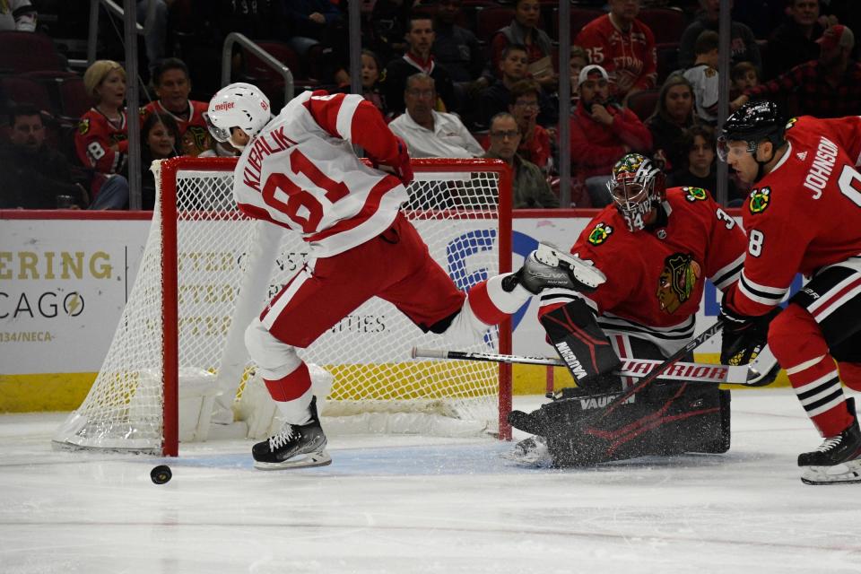 Detroit Red Wings left wing Dominik Kubalik (81) misses a shot on goal as Chicago Blackhawks goaltender Petr Mrazek (34) and Chicago Blackhawks defenseman Jack Johnson (8) defend during the first period at United Center in Chicago on Friday, Oct. 21, 2022.