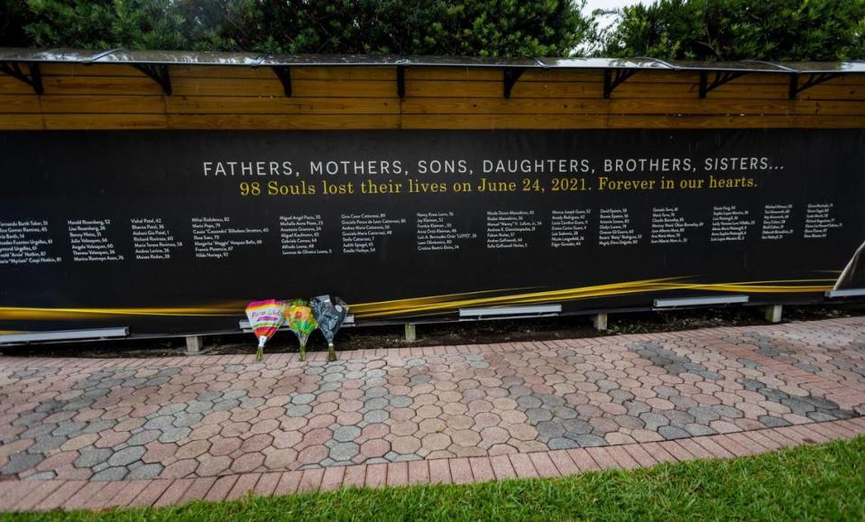 Three bunches of flowers at a memorial at the Tennis Center across the street from the site of Champlain Towers South, 88th Street and Collins Avenue in Surfside, June 22, 2023.