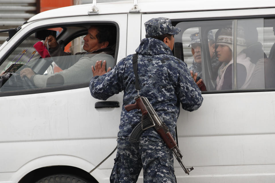 Un soldado inspecciona una camioneta que transporta pasajeros en El Alto, en las afueras de La Paz, Bolivia, el martes 12 de noviembre de 2019. (AP Foto / Natacha Pisarenko)