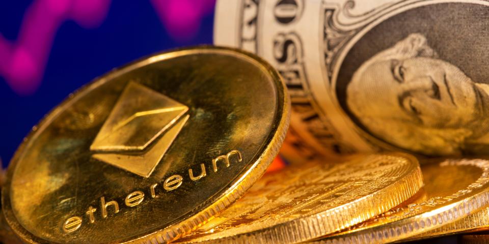 Gold coins with the Ethereum logo stacked in front of a U.S. 1 dollar bill.