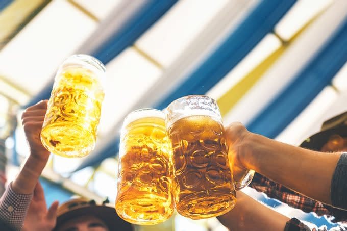 People Clinking Mass Beer Glasses At Oktoberfest In Munich