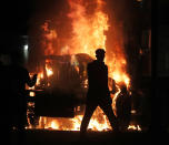 Aug 23, 2020; Kenosha, WI, USA; A man is seen as a city truck is on fire outside the Kenosha County Courthouse in Kenosha on Sunday, Aug. 23, 2020. Kenosha police shot a man Sunday evening, setting off unrest in the city after a video appeared to show the officer firing several shots at close range into the man's back. Mandatory Credit: Mike De Sisti/Milwaukee Journal Sentinel via USA TODAY NETWORK/Sipa USA