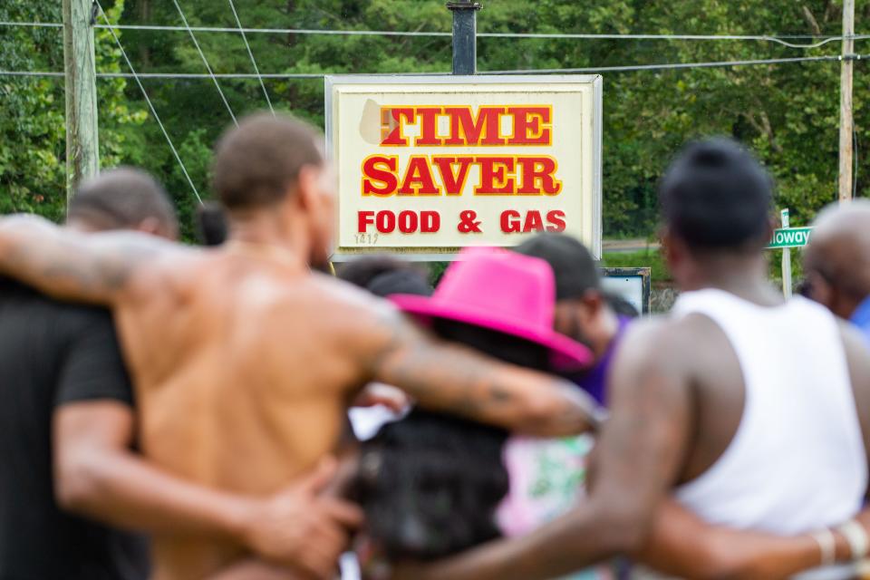 The Crime Prevention Task Force gathers in prayer with community members who had been watching the Tallahassee Police Department investigate Time Saver Food & Gas where a person was shot and killed Monday, July 31, 2023.