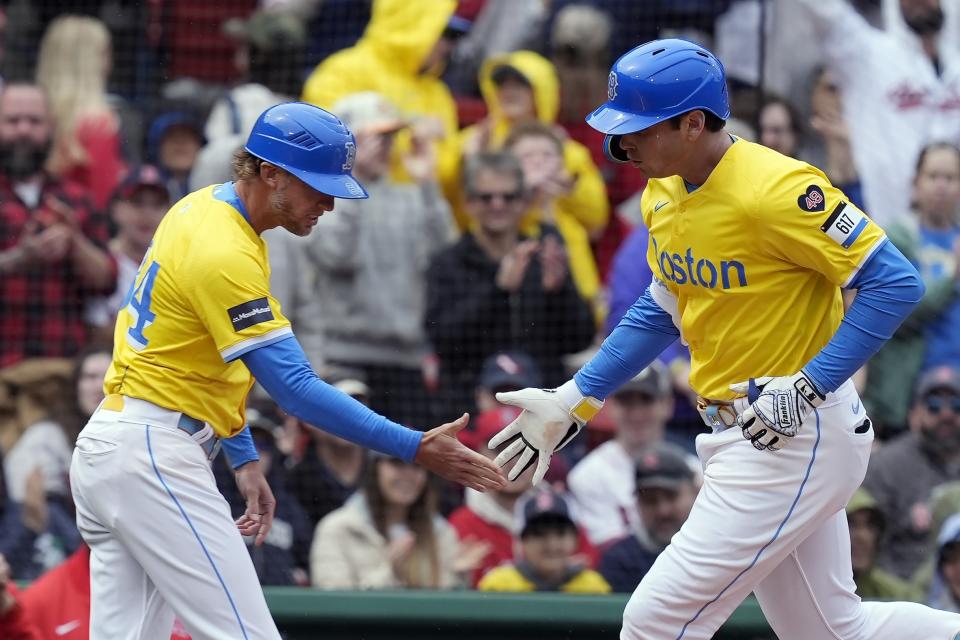 Boston Red Sox's Triston Casas, right, celebrates after his solo home run with third base coach Kyle Hudson, left, during the first inning of a baseball game against the Los Angeles Angels, Sunday, April 14, 2024, in Boston. (AP Photo/Michael Dwyer)