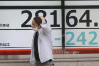 A man walks by an electronic stock board of a securities firm in Tokyo, Wednesday, May 19, 2021. Asian shares fell Wednesday, tracking a decline on Wall Street led by big technology stocks. (AP Photo/Koji Sasahara)