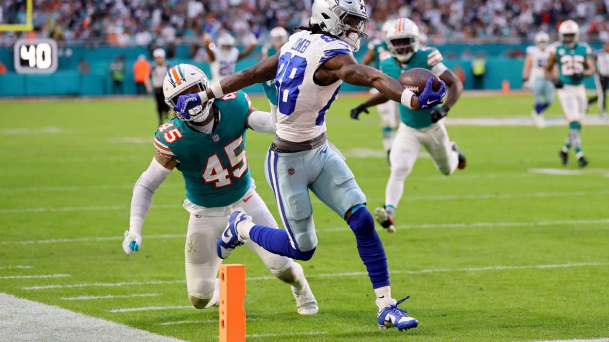 <div>MIAMI GARDENS, FLORIDA - DECEMBER 24: CeeDee Lamb #88 of the Dallas Cowboys scores a touchdown while defended by Duke Riley #45 of the Miami Dolphins during the first quarter at Hard Rock Stadium on December 24, 2023 in Miami Gardens, Florida. (Photo by Stacy Revere/Getty Images)</div>