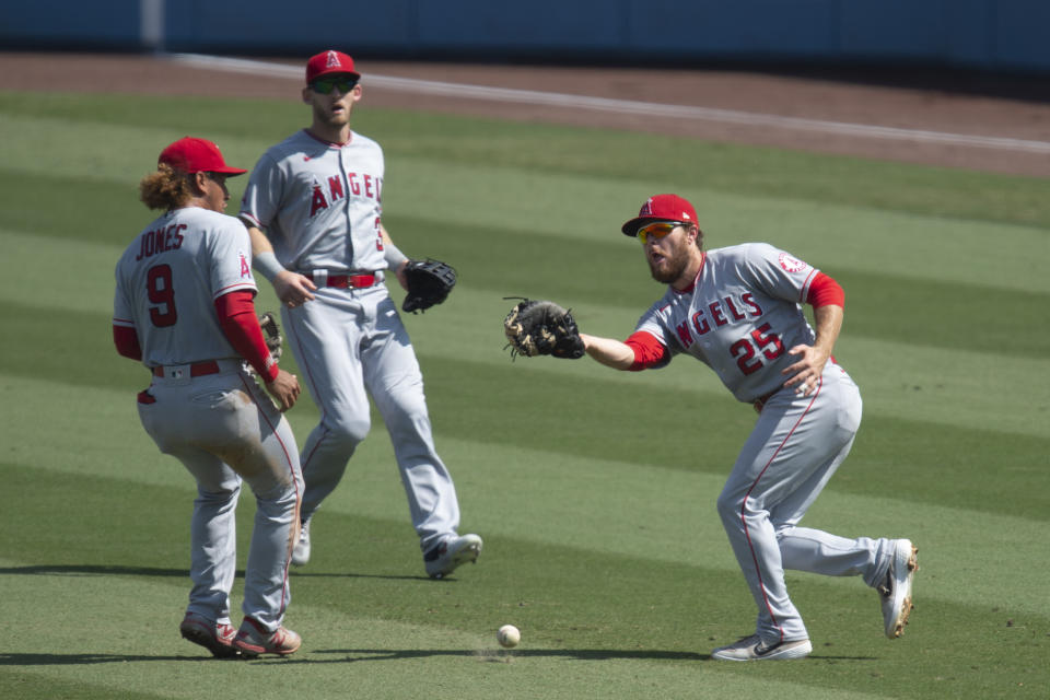 Los Angeles Angels first baseman Jared Walsh, right, cannot catch a fly ball off the bat of Los Angeles Dodgers' Justin Turner during the third inning of a baseball game in Los Angeles, Sunday, Sept. 27, 2020. (AP Photo/Kyusung Gong)