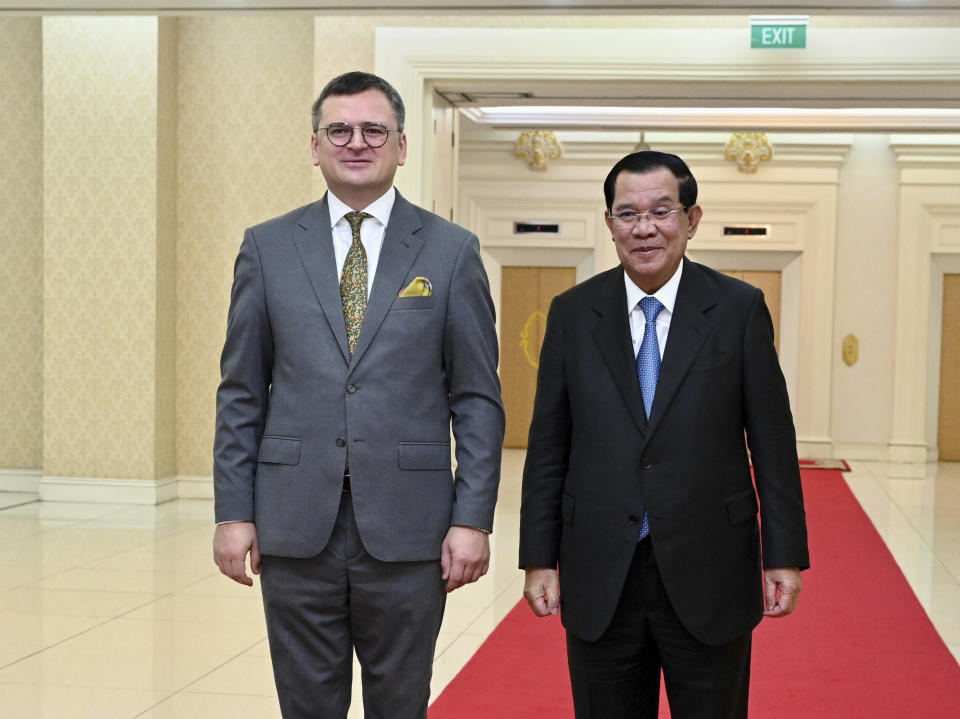 In this photo provided by Cambodia's Government Cabinet, Cambodian Prime Minister Hun Sen, right, and Ukrainian Foreign Minister Dmytro Kuleba, left, pose for a photo, during a welcome meeting at Peace Palace in Phnom Penh, Cambodia, Wednesday, Nov. 9, 2022. (Kok Ky/Cambodia's Government Cabinet via AP)