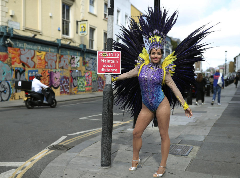 Pilates instructor Juliana Campos poses in her carnival costume in Notting Hill, London, on what would have been the weekend of the Notting Hill Carnival, after the 2020 carnival was cancelled due to the coronavirus pandemic, Sunday, Aug. 30, 2020. (Yui Mok/PA via AP)