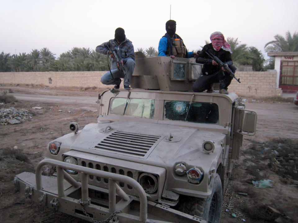 FILE - in this Thursday, Jan. 9, 2014, file photo, gunmen sit on top of an Iraqi military vehicle left by Iraqi soldiers during clashes in Fallujah, Iraq. More than a month after jihadist militants seized control of parts of Iraq’s western Anbar province, an unsettling realization is sinking in: Iraq’s government could face a tougher time beating back an insurgency there than the hard slog the Americans faced last decade. The reasons include a deep distrust of the government by Iraqi Sunnis, insufficient resources, sectarian tensions enflamed by the war in Syria and divisions among the tribes that make up Anbar’s social fabric. (AP Photo, File)