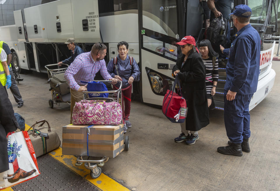 People arrive at the San Antonio International Airport Tuesday, March 3, 2020 after being released from quarantine at JBSA-Lackland. The people were evacuated from the coronavirus-infected Diamond Princess cruise ship in Japan and had been held in quarantine at Lackland to ensure they were not infected with the virus. (William Luther/The San Antonio Express-News via AP)