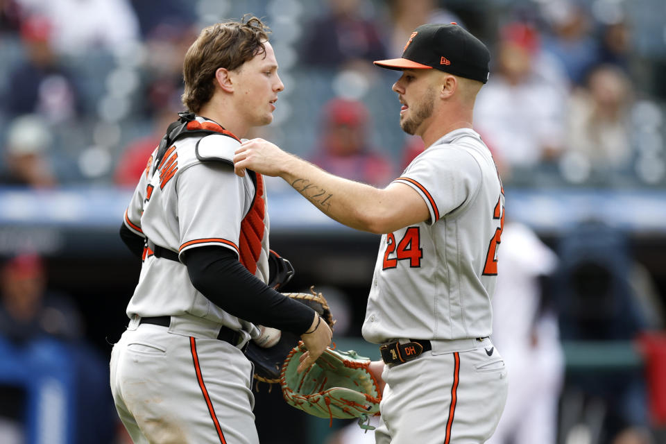 Baltimore Orioles relief pitcher DL Hall (24) and catcher Adley Rutschman, left, celebrate after a win over the Cleveland Guardians in a baseball game, Sunday, Sept. 24, 2023, in Cleveland. (AP Photo/Ron Schwane)