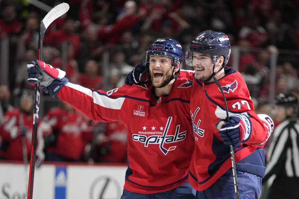 Washington Capitals right wing Nic Dowd, left, celebrates with defenseman Alexander Alexeyev after Alexeyev scored a goal in the first period of an NHL hockey game against the Buffalo Sabres, Wednesday, Nov. 22, 2023, in Washington. (AP Photo/Mark Schiefelbein)