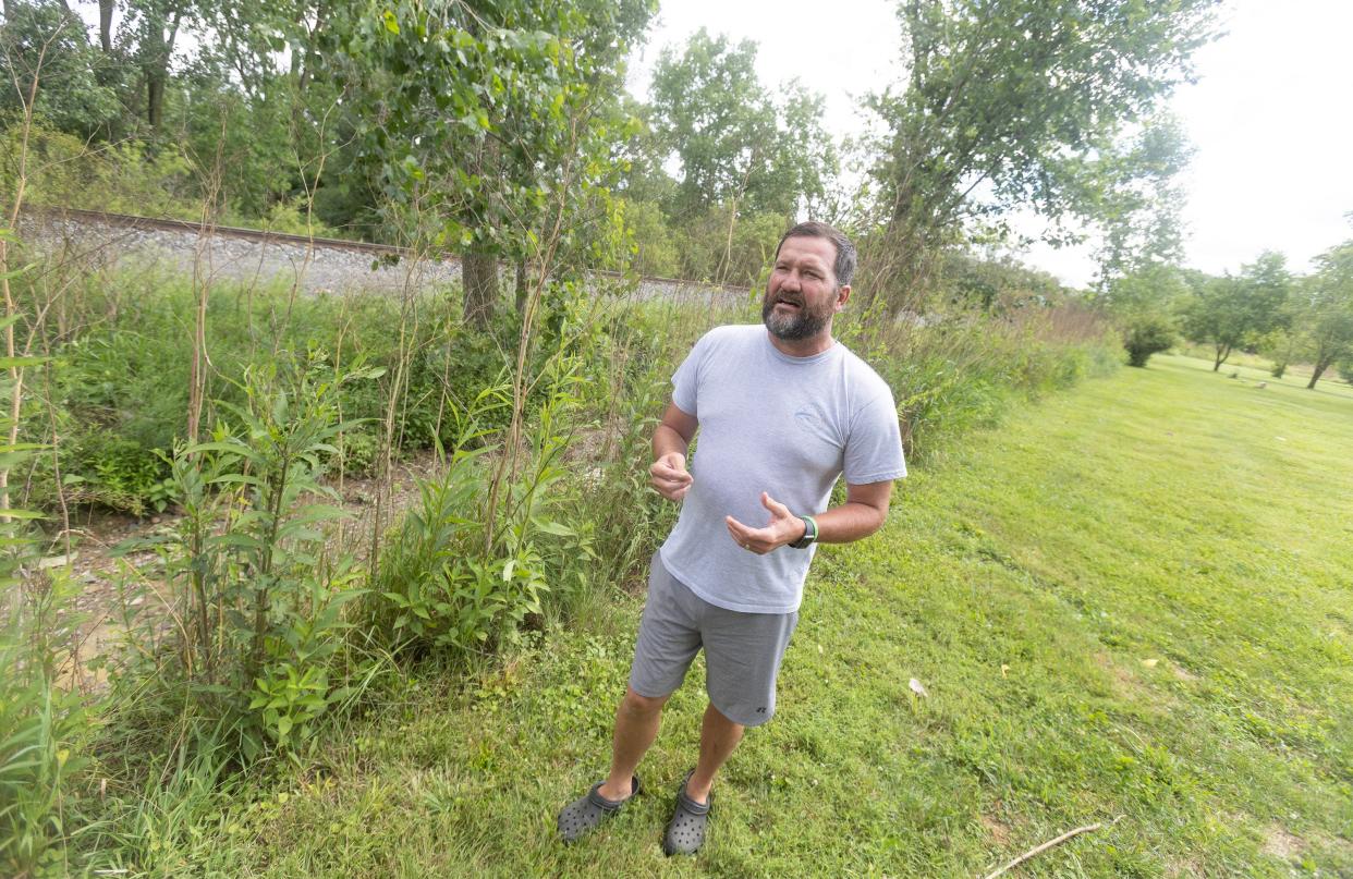Chase Horvath, who lives in the 14000 block of Lawmont Street NW, talks about the trees that were removed from his property to assist with the cleanup from last year's Norfolk Southern train derailment in Lawrence Township.
