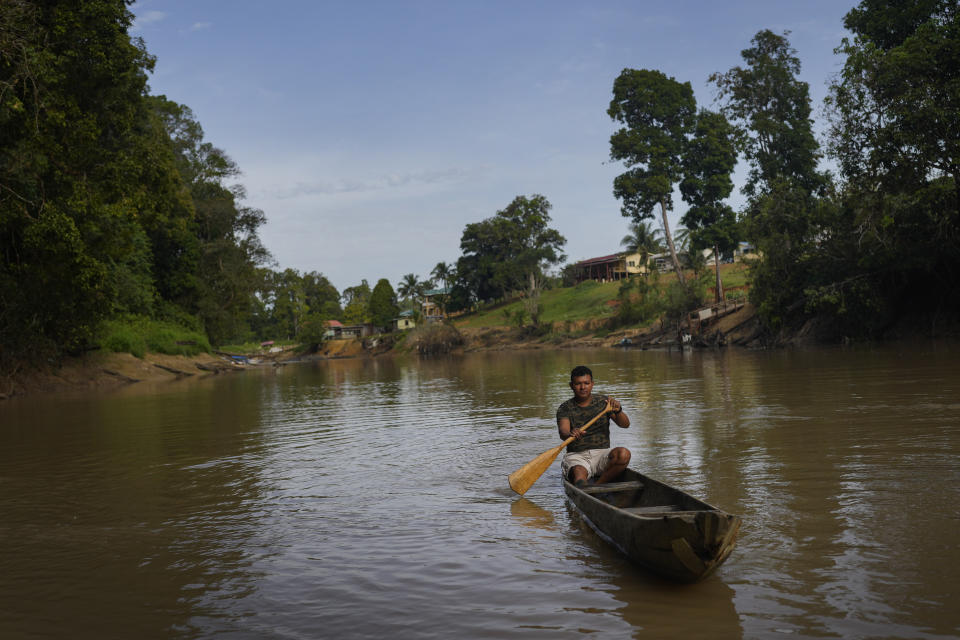 Amerindian Orin Fernandes, a toshao, or Indigenous leader, paddles a wooden canoe as he poses for a photo, in Chinese Landing, Guyana, Tuesday, April 18, 2023. Residents are fighting in court to regain full control of the rights to the nearby Tassawini gold mine. (AP Photo/Matias Delacroix)