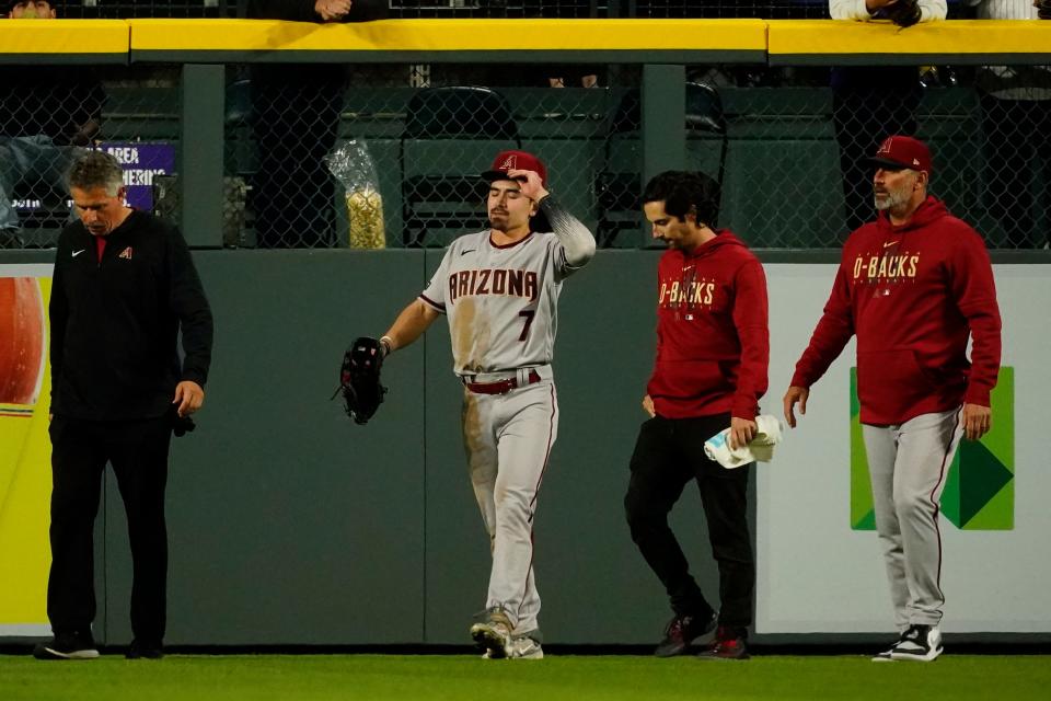 Apr 29, 2023;  Denver, Colorado, USA;  Arizona Diamondbacks left fielder Corbin Carroll (7) leaves the game after crashing into the center field wall at Coors Field.  Carroll left the game after the play.  Mandatory Credit: Michael Madrid-USA TODAY Sports