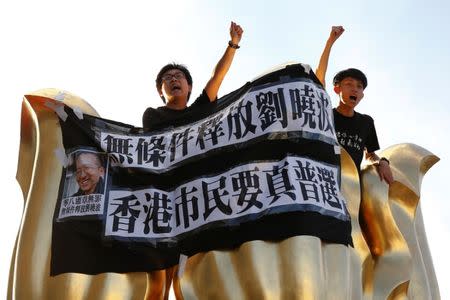 Pro-democracy activists chant slogans on the Golden Bauhinia Square, a gift from China at the 1997 handover, during a protest a day before Chinese President Xi Jinping is due to arrive for the celebrations, in Hong Kong, China June 28, 2017. REUTERS/Damir Sagolj