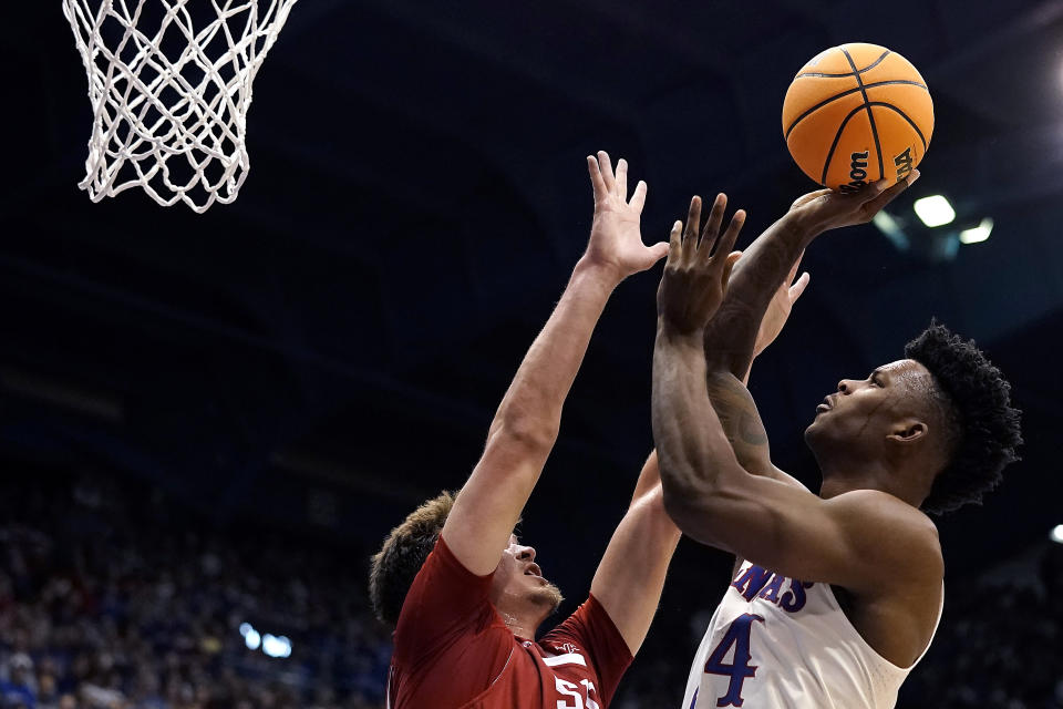 Kansas forward K.J. Adams Jr., right, shoots over Southern Utah forward Maizen Fausett during the first half of an NCAA college basketball game Friday, Nov. 18, 2022, in Lawrence, Kan. (AP Photo/Charlie Riedel)