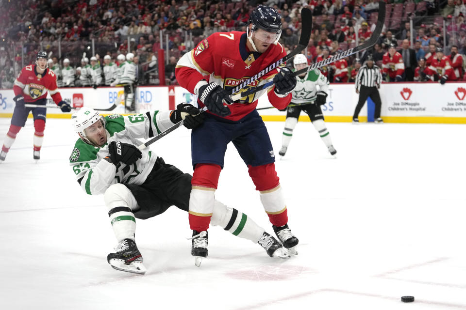 Dallas Stars right wing Evgenii Dadonov (63) and Florida Panthers defenseman Dmitry Kulikov (7) fight for position during the first period of an NHL hockey game, Wednesday, Dec. 6, 2023, in Sunrise, Fla. (AP Photo/Lynne Sladky)