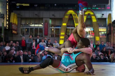 Cuban wrestler Livan Lopez Azcuy slams U.S. wrestler David Taylor during their "Salsa in the Square" wrestling match in New York's Times Square, May 21, 2015. REUTERS/Brendan McDermid