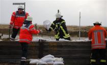 Firefighters reinforce a dyke at the North Sea with sandbags in Sahlenburg, near Cuxhaven, December 6, 2013. REUTERS/Fabrizio Bensch