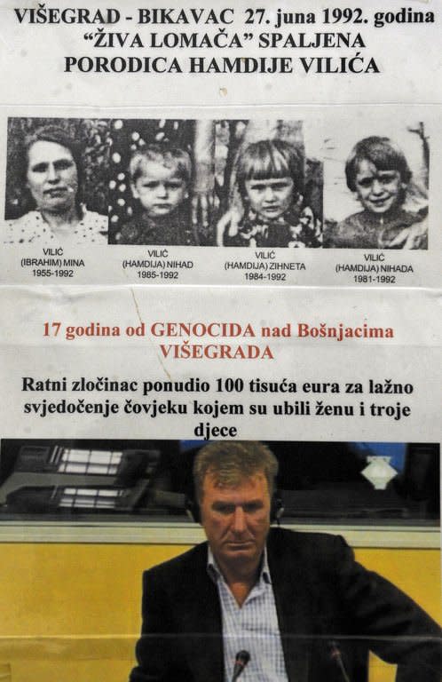 Hamdija Vilic, a Bosnian Muslim and survivor of the 1992 massacres in Visegrad, is pictured during his deposition at the war crimes court sitting in front of a poster of his wife and three children, who were killed in the massacre